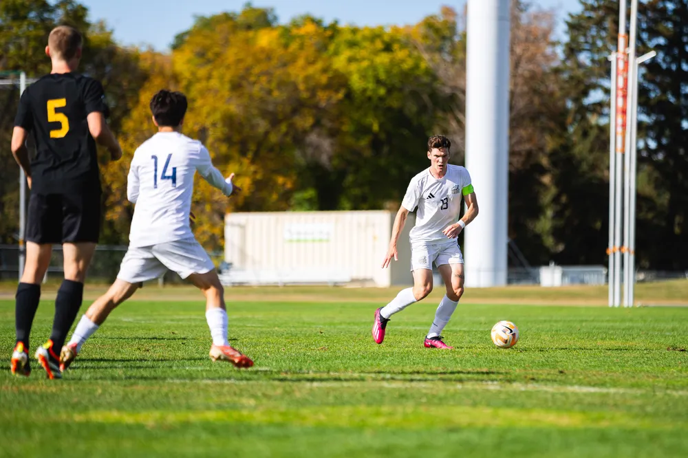 UBC players passing the ball to each other on the field