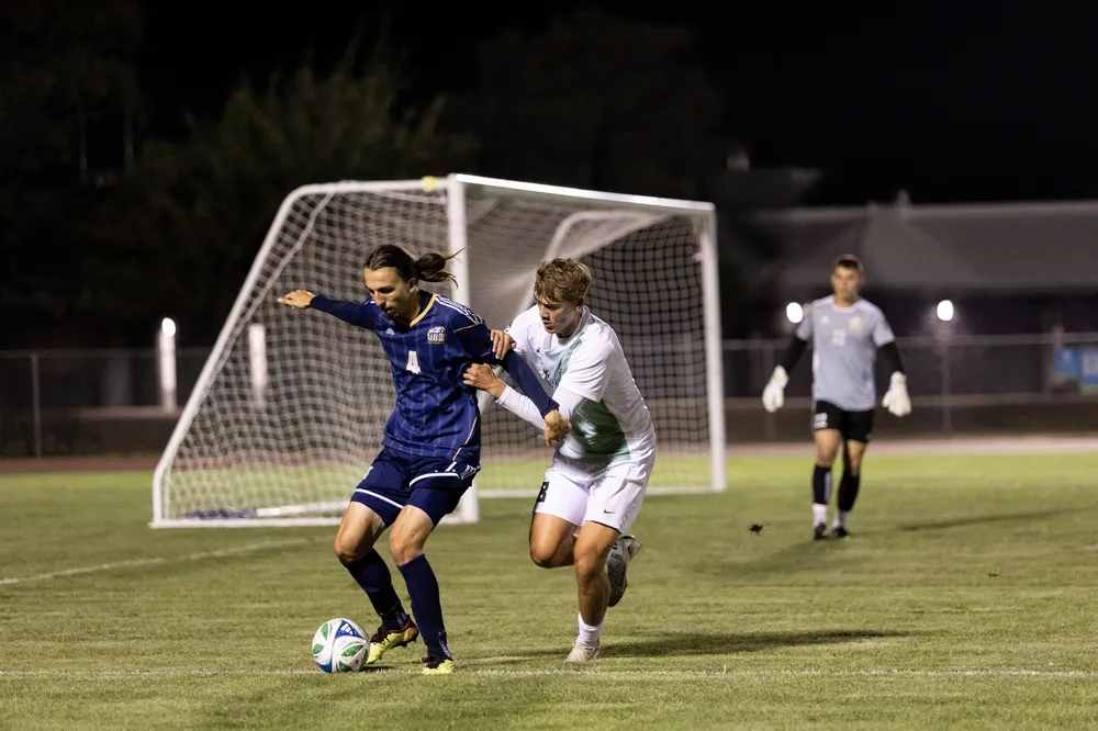 A UBC player is pressured by a Cascade deep in his own end.