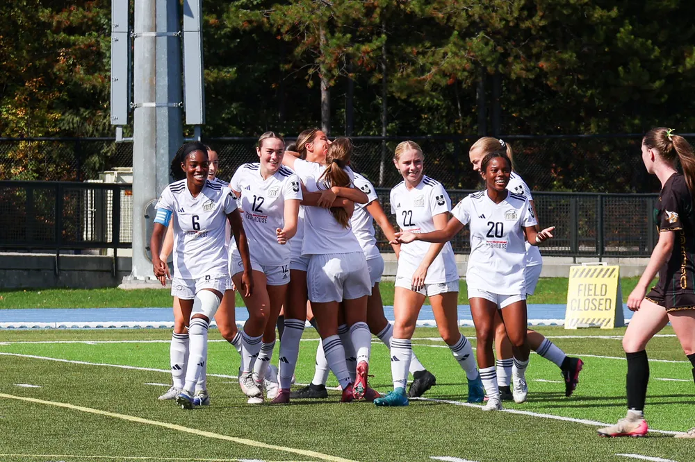 UBC's women's soccer team celebrates together against UNBC