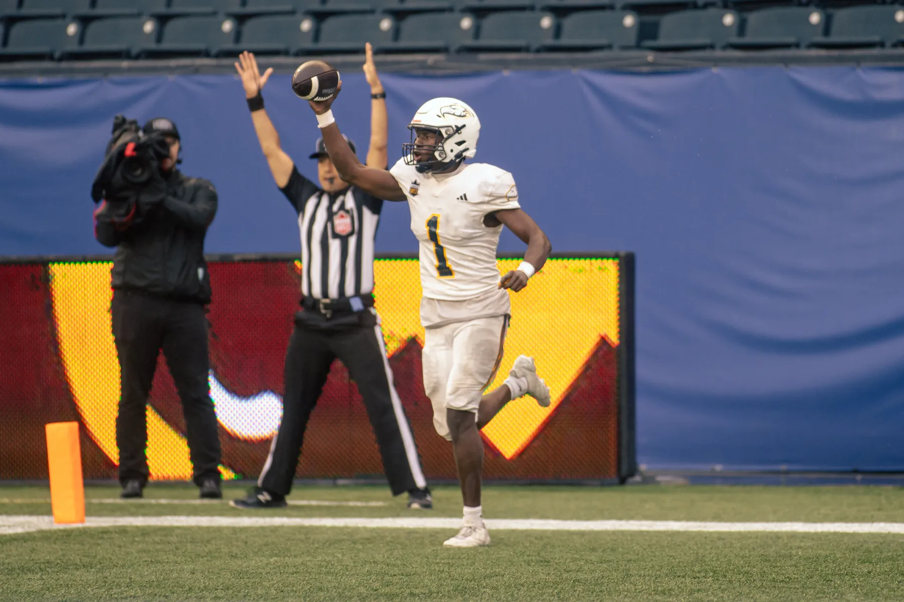 A UBC player holds the ball up in celebration.