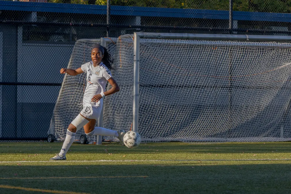 Taiya Dennehy runs with the ball in front of her own net.