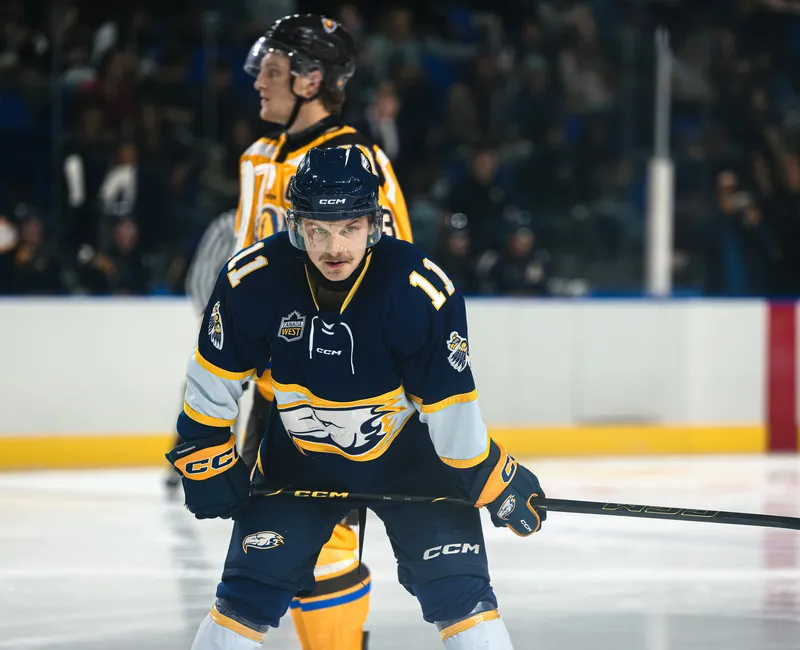A UBC player skates on the ice with both hands on his stick.