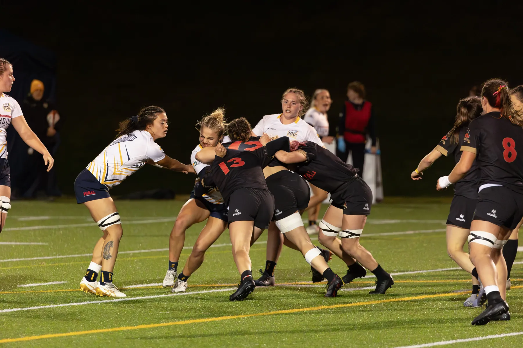 A group of Laval players in black and red, try to run through a group of T-Birds in white.