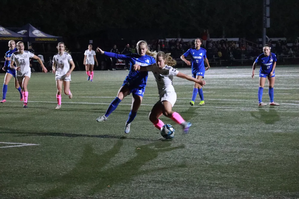 Harrison gets a shot off towards the net as a Vike crashes in towards her.