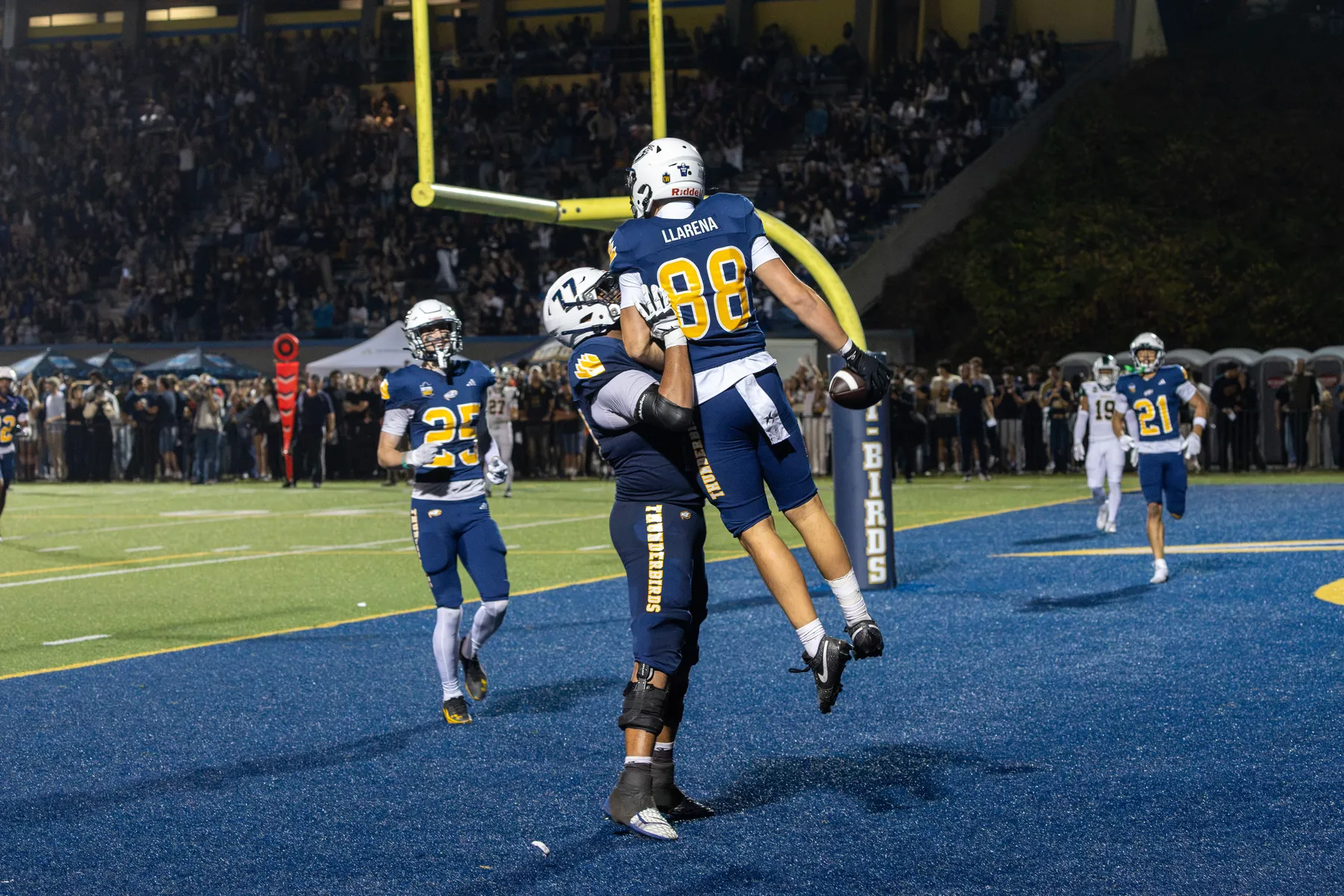 A UBC player is held up by another in the end zone.