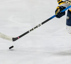 A UBC player holds onto a stick and handles the puck.