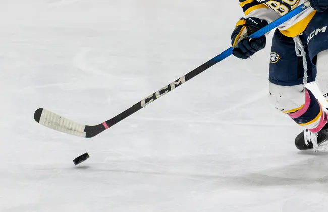A UBC player holds onto a stick and handles the puck.