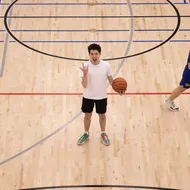 Our basketball writer, Ian, stands in the middle of the court at Rec North, making a face at the camera while holding a ball.