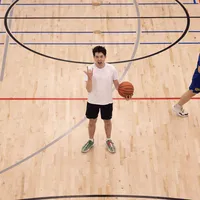 Our basketball writer, Ian, stands in the middle of the court at Rec North, making a face at the camera while holding a ball.