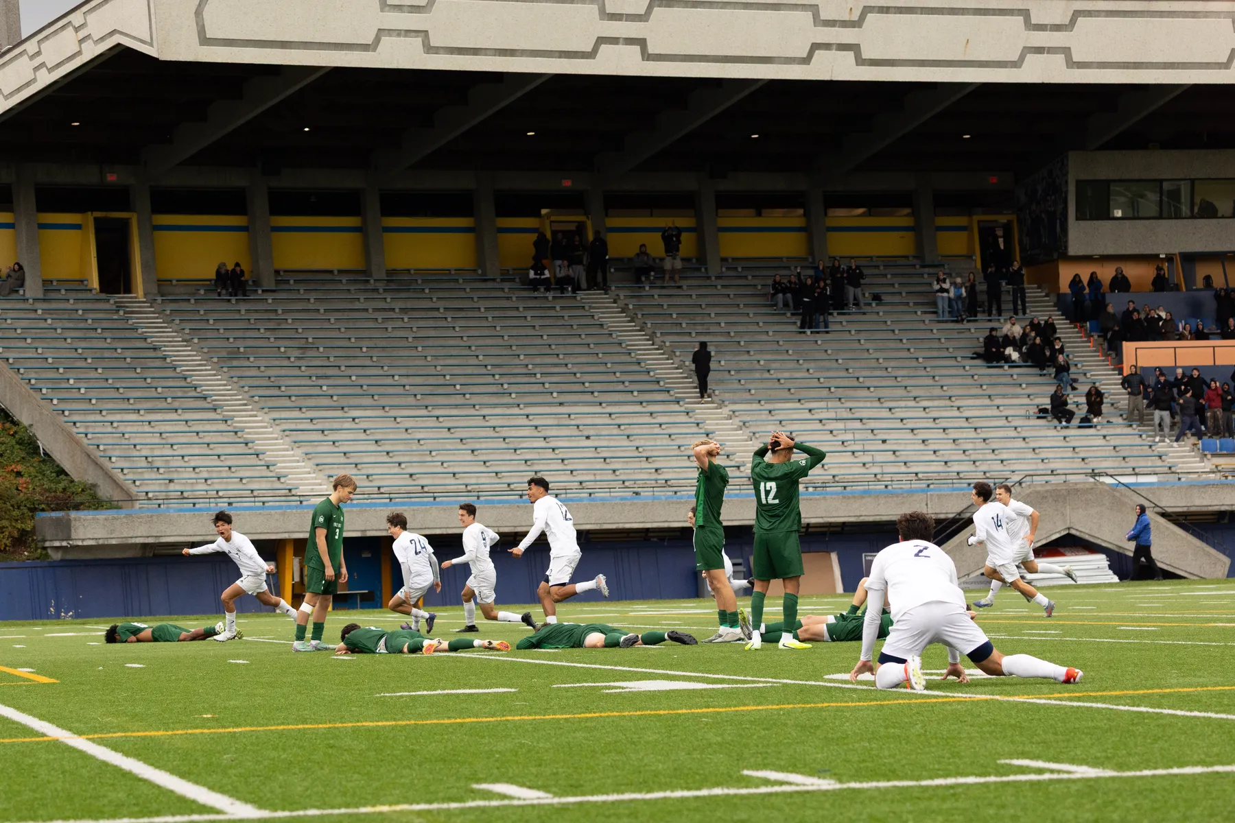 T-Birds players in white run and jump in celebration, while UFV players fall to the ground, or stand in shock with their hands over their heads.