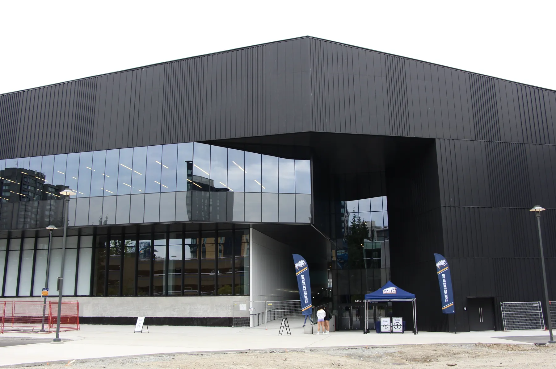 A photograph of the new Recreation Centre North, with UBC Thunderbirds banners and a tent marking the entrance for the building's soft opening.
