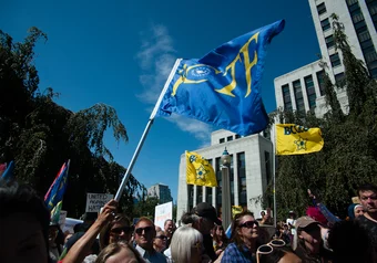 Demonstrators against racism & islamophobia wave flags during speeches at City Hall.