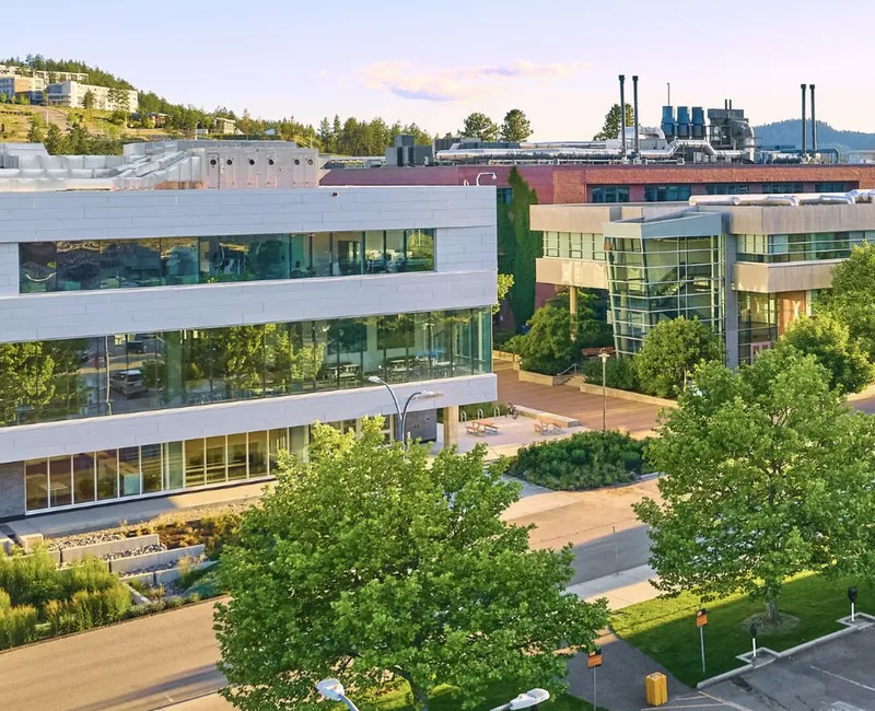 A photo of buildings at UBCO, with student residences on the hills in the background.