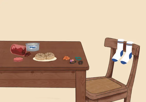 An illustration of a table and chair, with socks over the chair and things scattered over the table, such as jam, cream cheese, hair ties and an everything bagel.