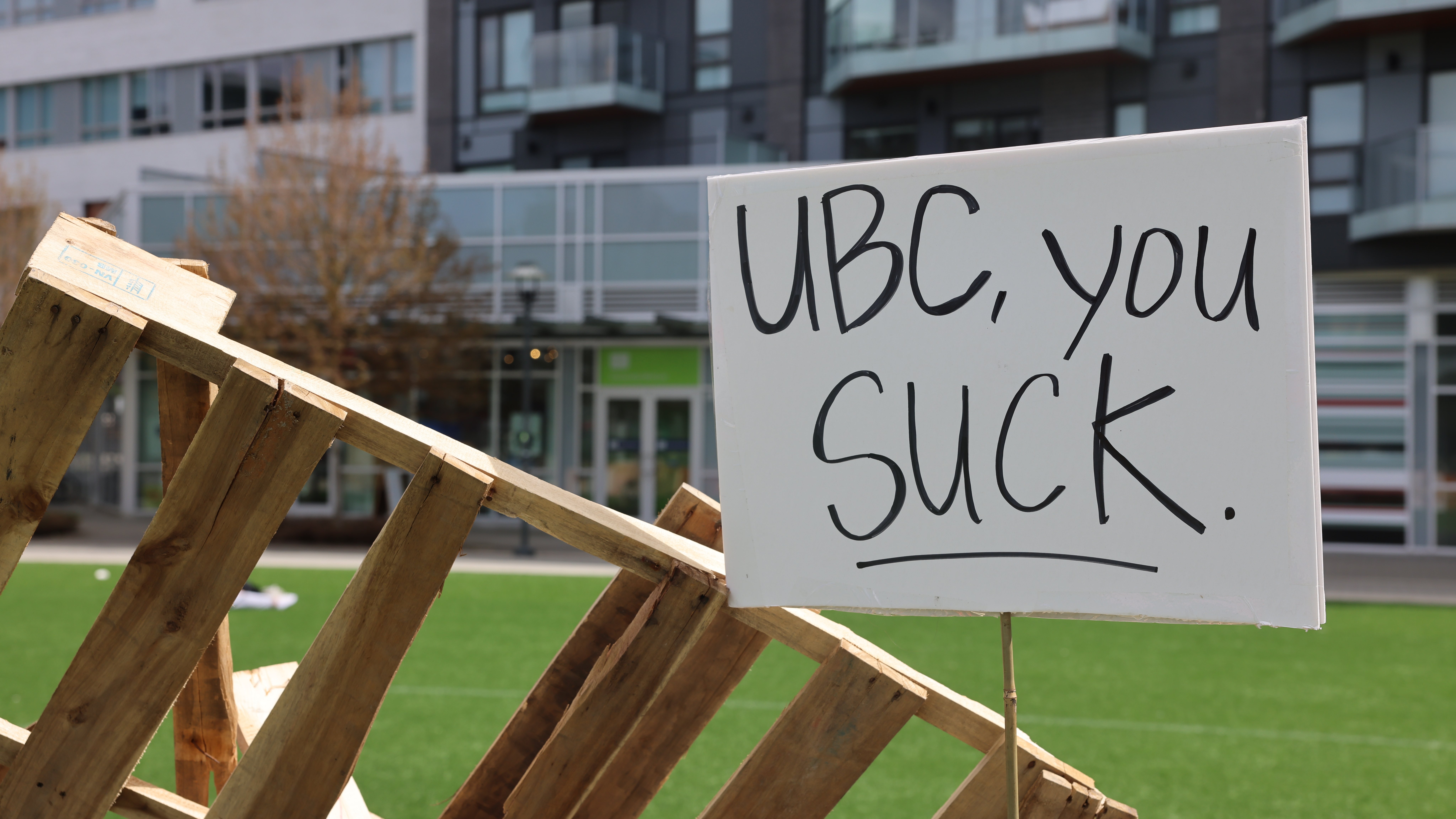 A sign on a barricade that reads 'UBC sucks'.