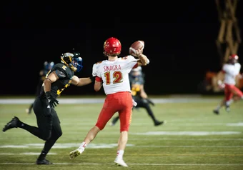 UBC Number 33 attempts a sack against Calgary QB #12.