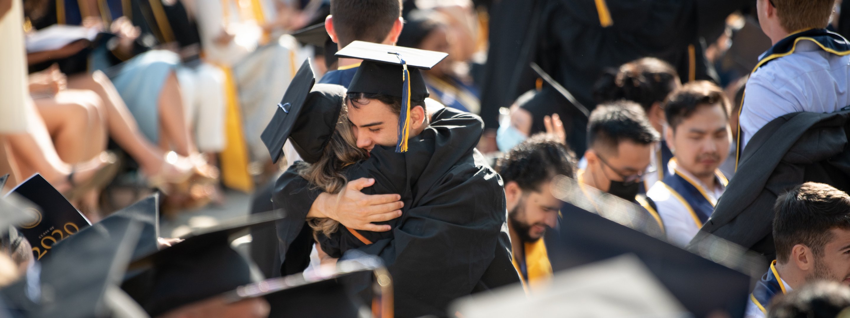 Two graduates hugging