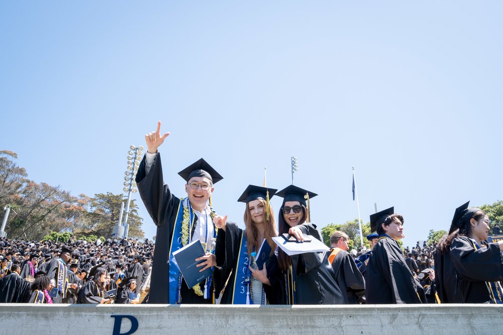 Graduates pose on the railing at Memorial Stadium