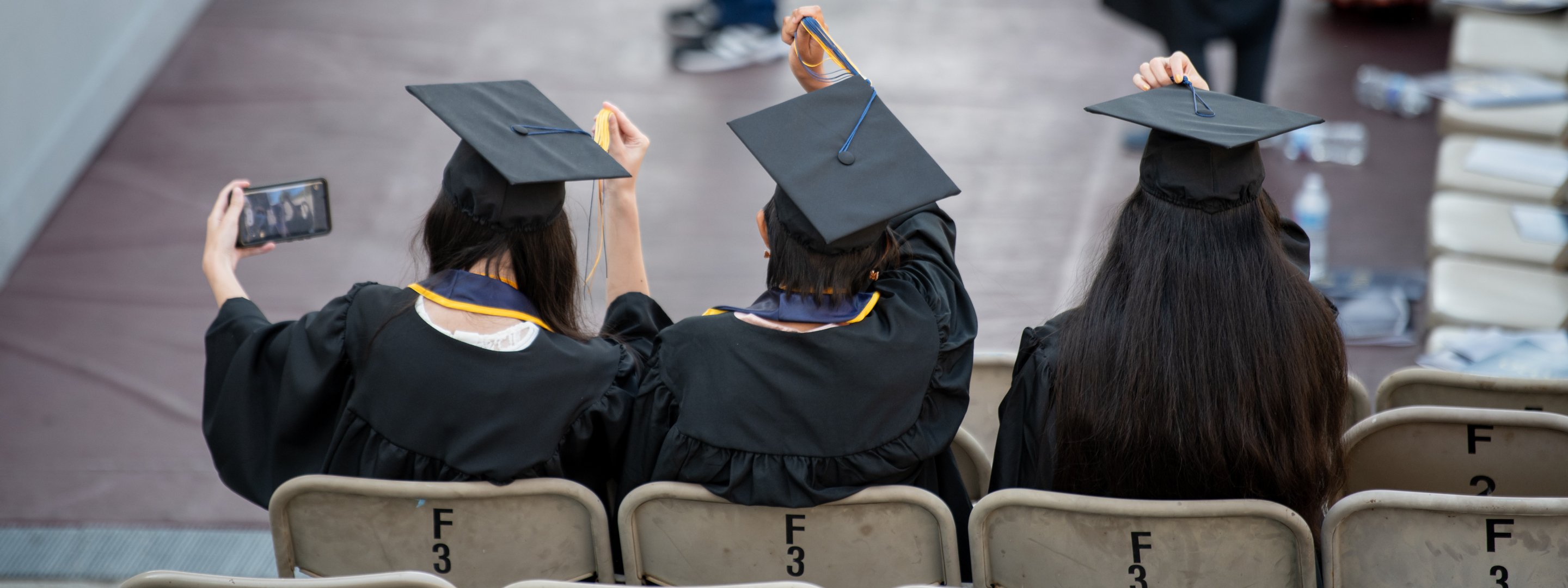 Students pose for a selfie in their caps and gowns