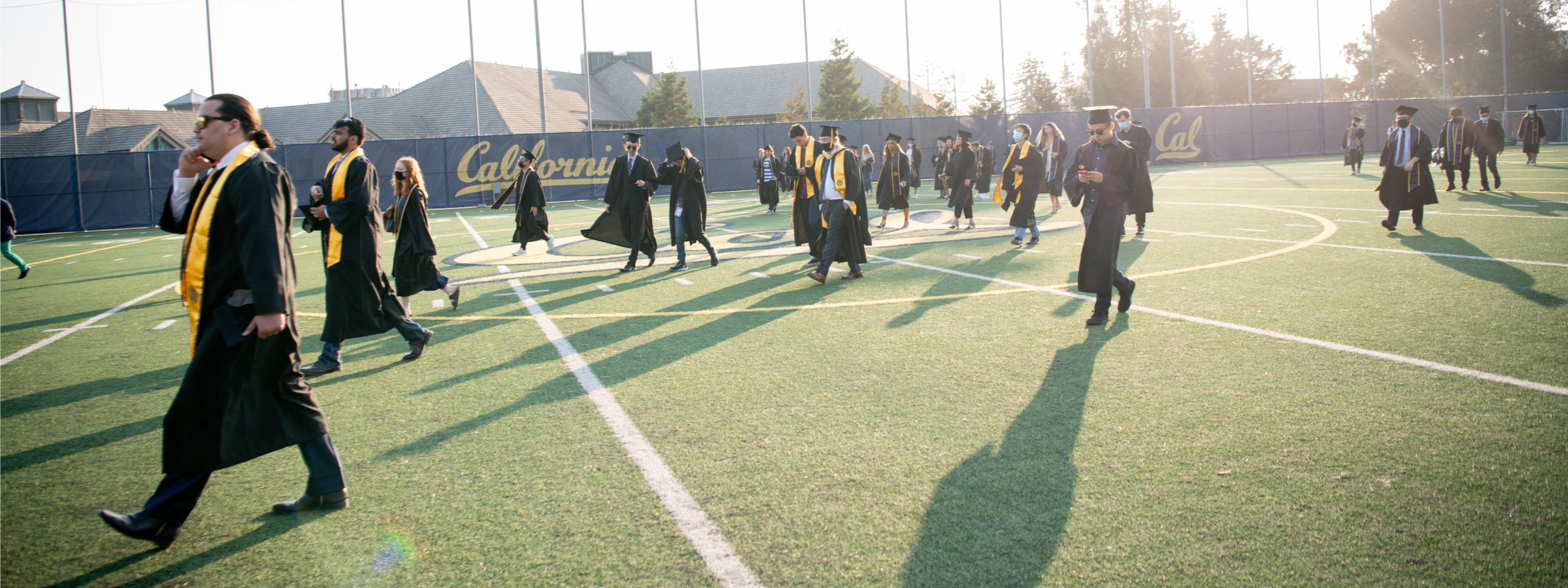 Graduates walking across football field