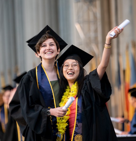 photograph of two graduates on stage