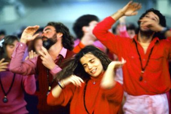 Image of a group of people dancing in matching red and pink clothing