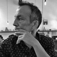 A black and white photo of a contemplative Pierluigi Serraino looking off to the side