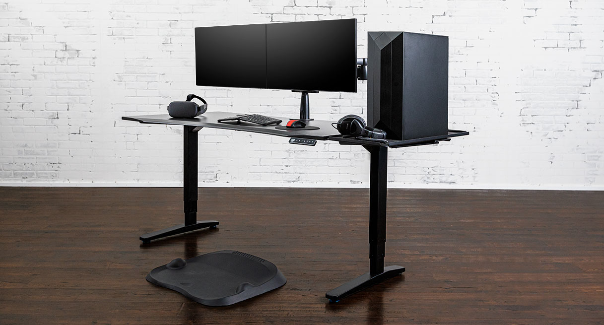 Black Eco Curve ergonomic UPLIFT gaming desk with a large gaming tower on a Desk Extension instead of the desktop