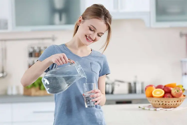 Mujer sirviendose un vaso de agua