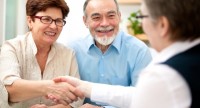 A happy couple shaking hands with an adviser.jpg