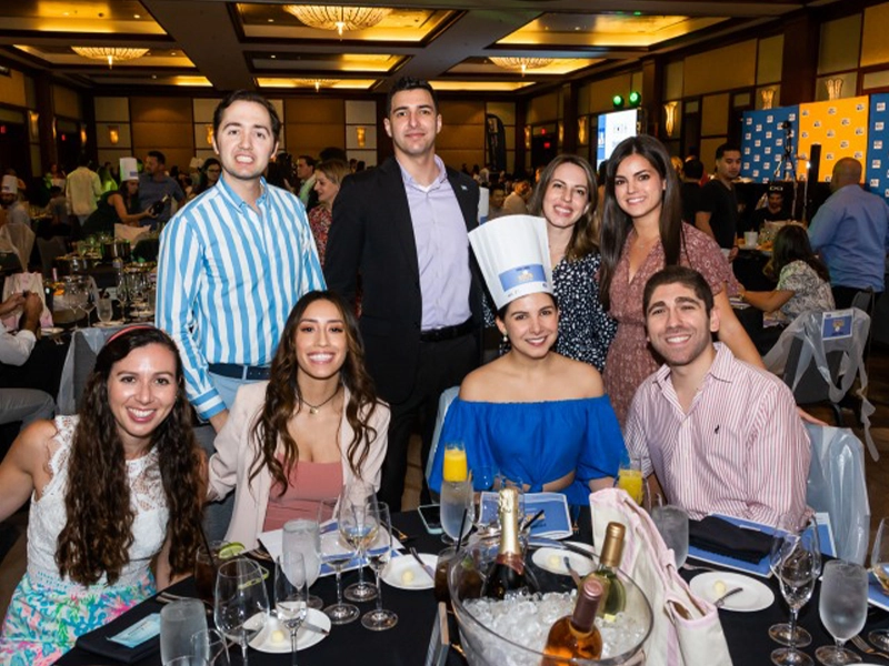 people around the table posing during event