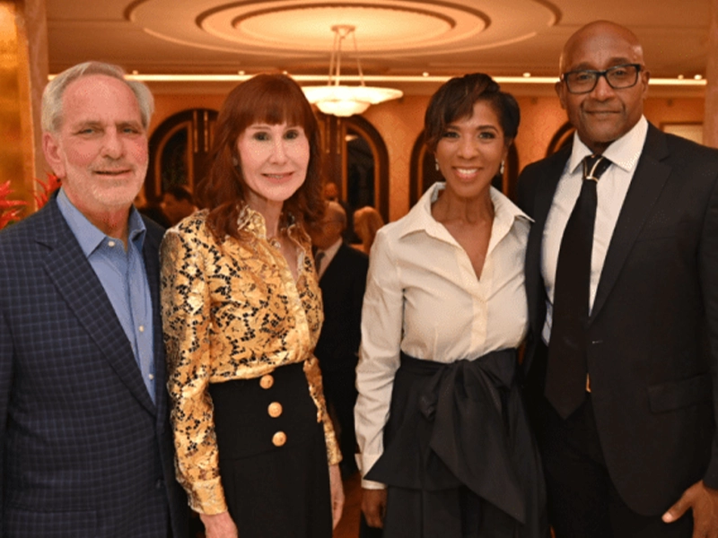 four people smiling and posing at the camera