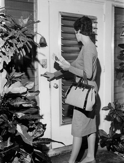 Woman nocking on a house front door