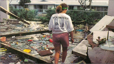Volunteer in front of ruins of Hurricane Andrew