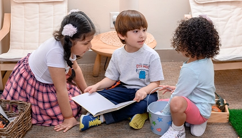 three children sharing a book