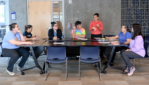 group of teachers talking in school classroom