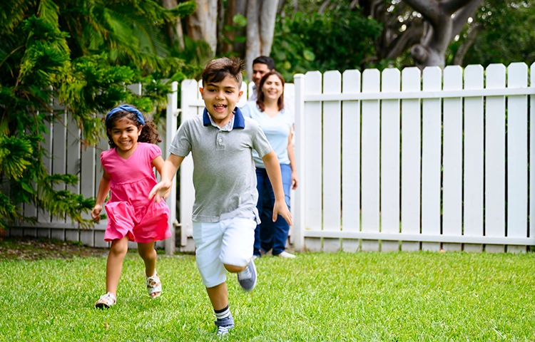 children running on the lawn of their house