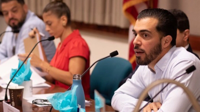 man speaking from auditorium table with more colleagues