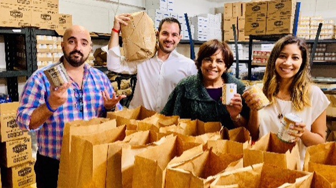 four people working with paper packaging