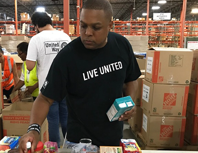 medium shot of man packing objects in boxes