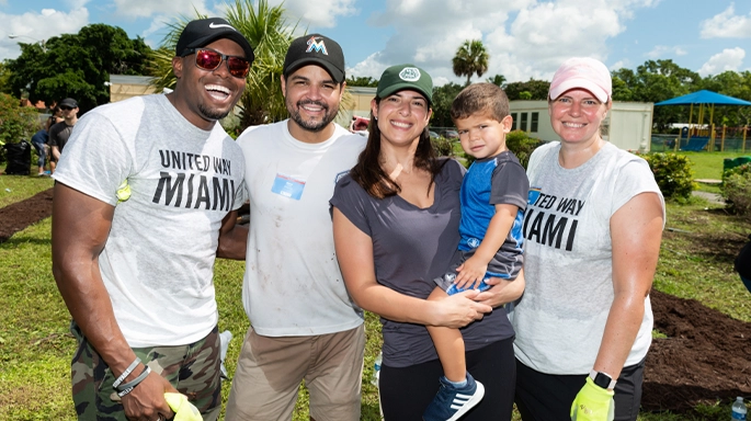 4 adults and a child smiling and posing at the camera