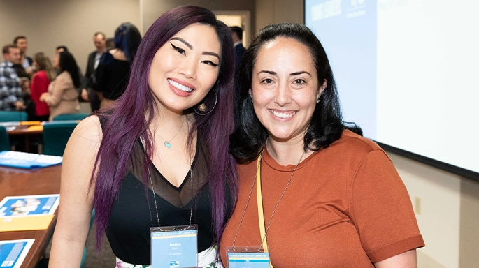 two women posing at the camera during event