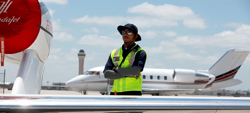 A person standing outdoors in front of airplanes