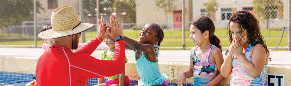 A coach and young swimmers in a swimming pool