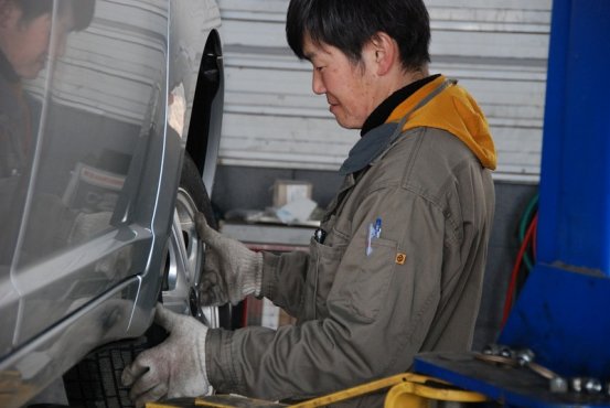 職場の自動車整備工場で整備士として仕事をする山田昌司さん