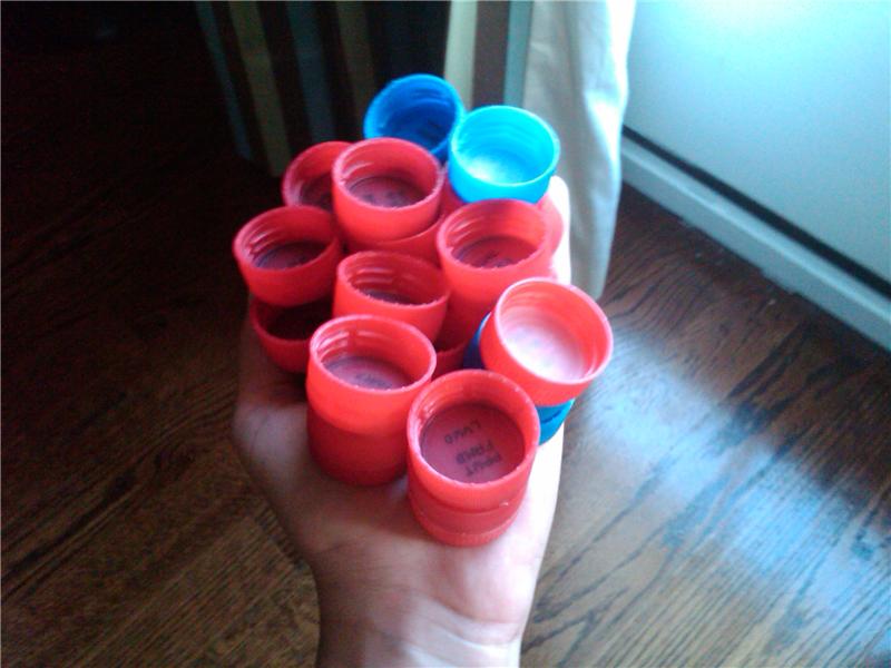 Most Coca-Cola Bottle Caps Held In Hand At Once