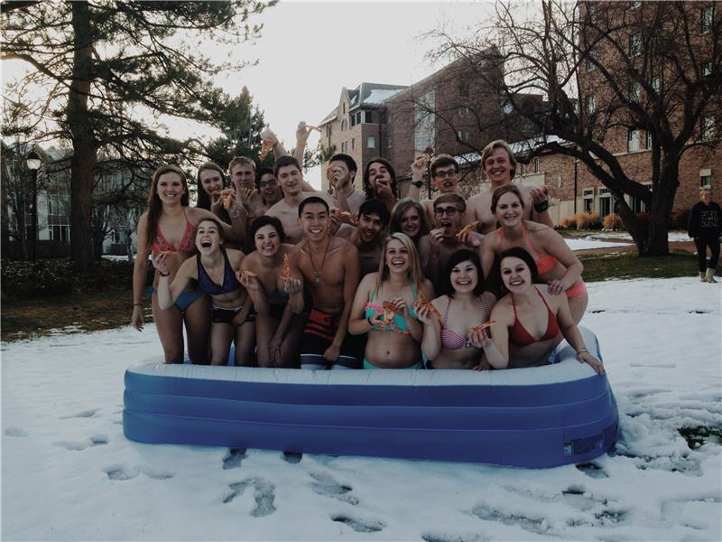 Most College Students In An Inflatable Pool Eating Pizza With Snow On The Ground