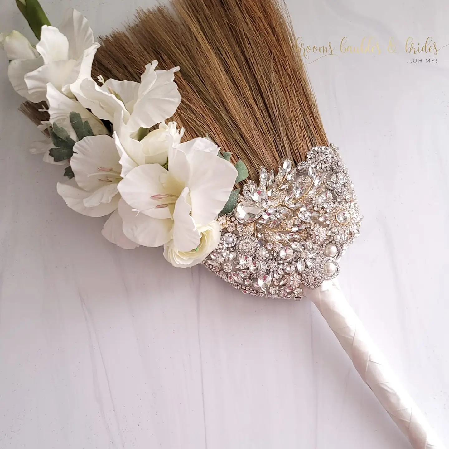 The logo or business face of "Brooms Baubles N Brides...Oh My!"