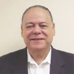 Headshot of a man, he smiles at the camera