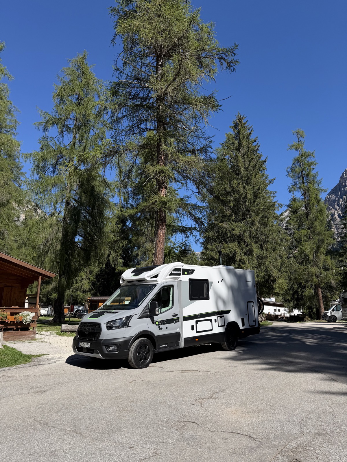 Kamper na drodze pod wysokimi drzewami